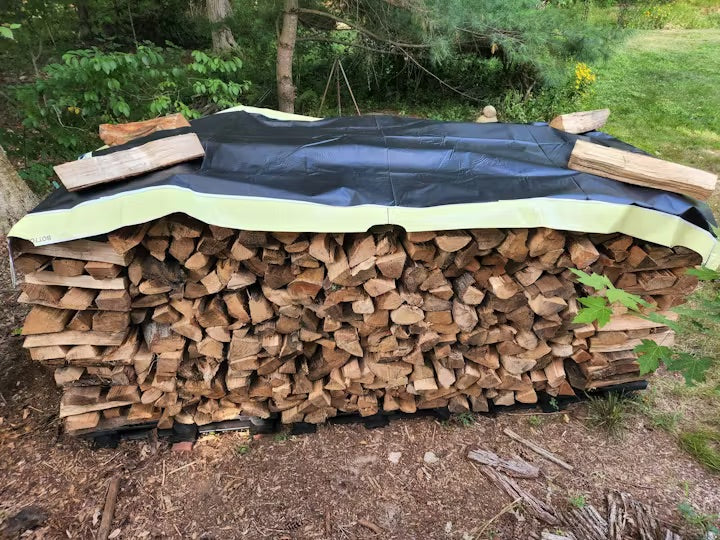 Repurposed vinyl tarp covering stacked lumber for outdoor storage