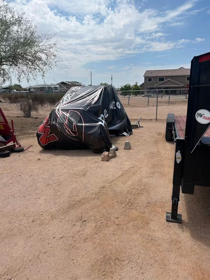 Upcycled black vinyl tarp used as a waterproof boat cover for outdoor storage